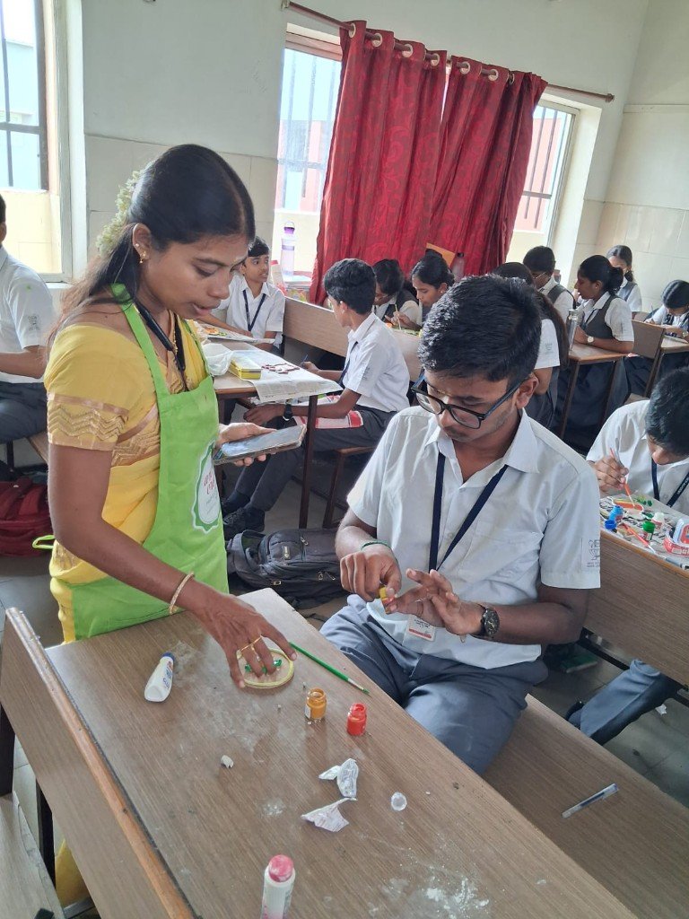 An instructor guides a student during the Fevicryl art and craft session